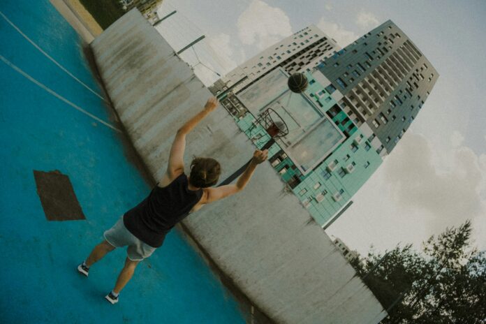 Man playing basketball on a blue court.